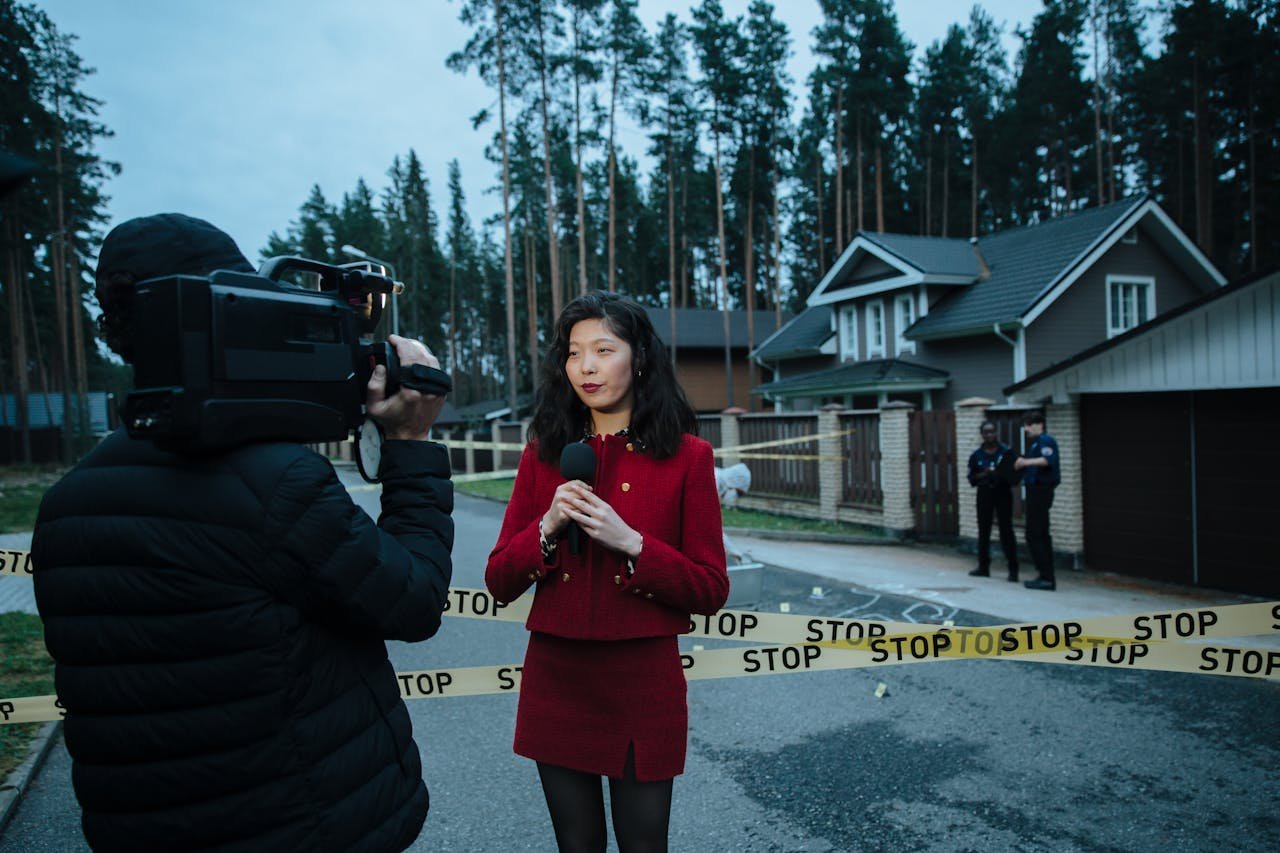 why-choose-us Journalist reporting live from a taped crime scene with cameraman and police.