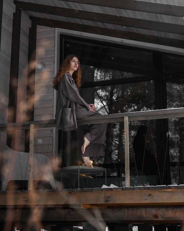 services-01 A woman enjoys a tranquil moment on a cozy balcony, surrounded by nature.